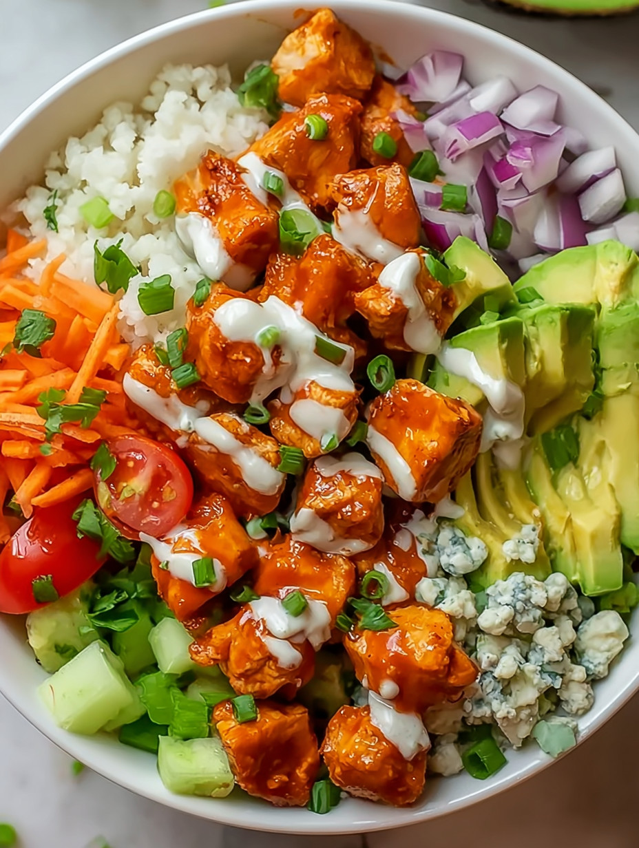 A bowl of food with chicken, rice, and vegetables.