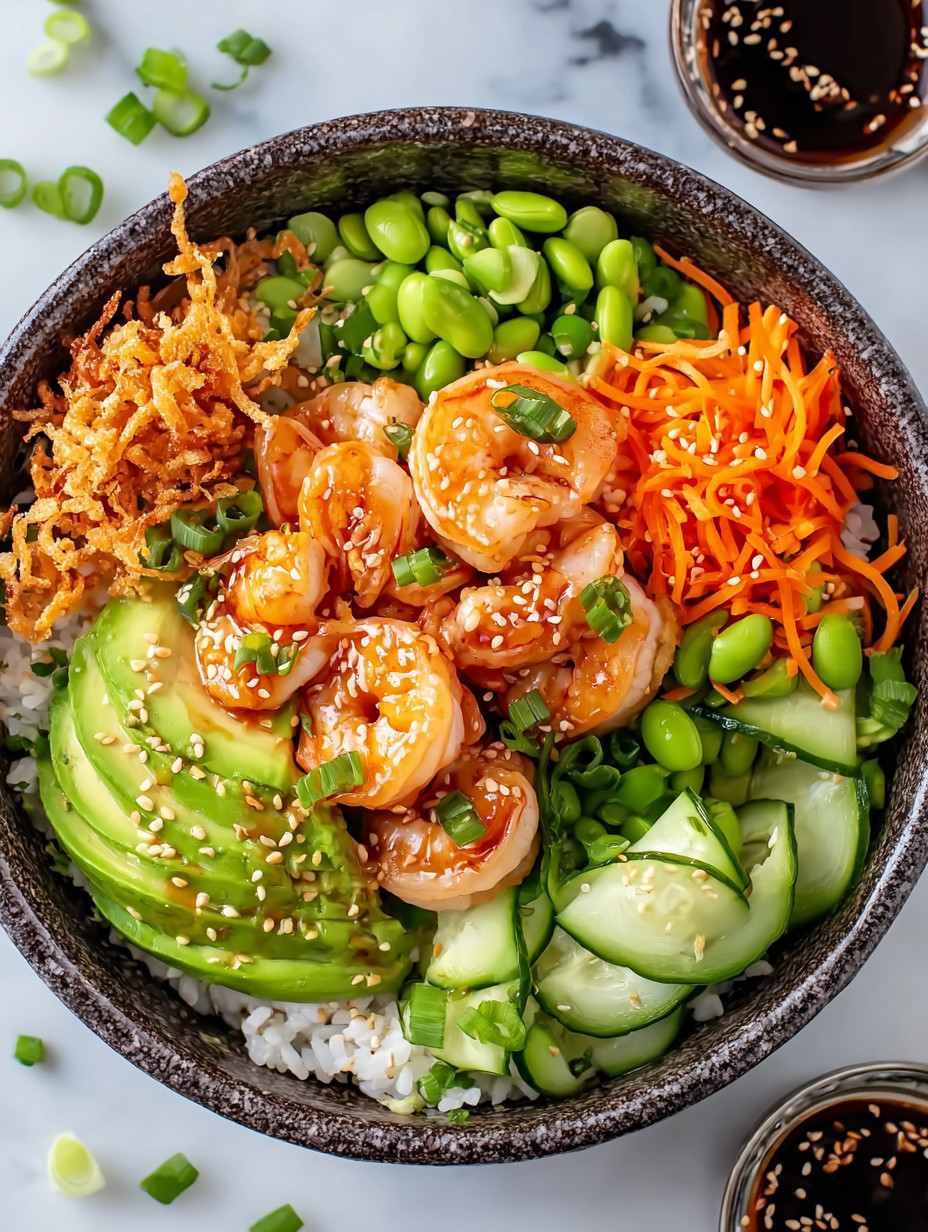 A bowl of food with shrimp, avocado, and carrots.