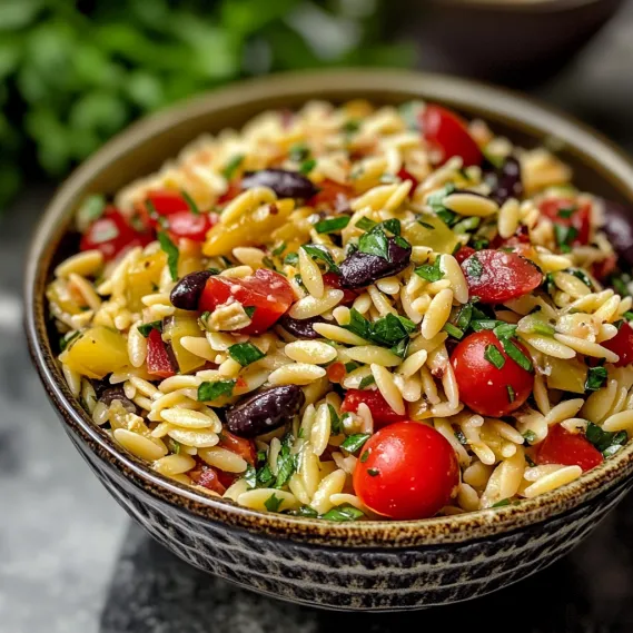 A bowl of pasta with tomatoes and olives.