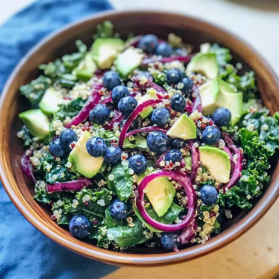 A bowl of salad with blueberries and avocado.