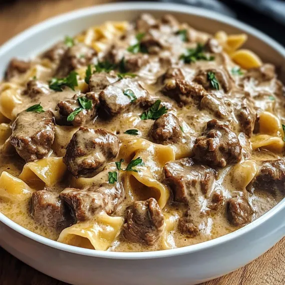 A bowl of pasta with meat and sauce.