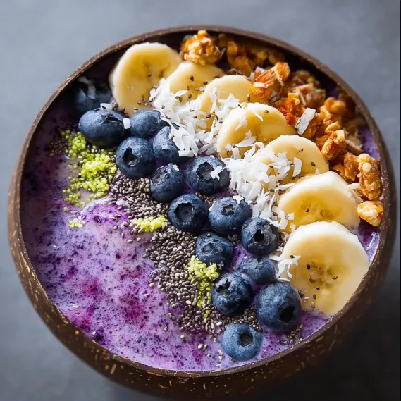 A bowl of fruit with bananas, blueberries, and walnuts.