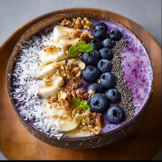 A bowl of yogurt with bananas, nuts, and blueberries.