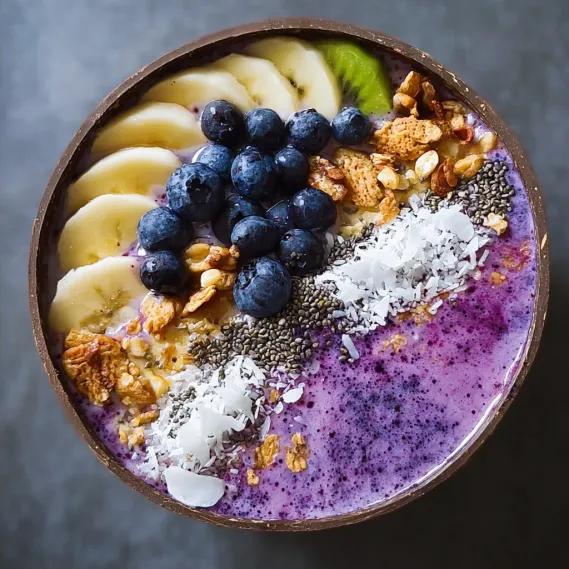 A bowl of fruit with bananas, blueberries, and nuts.