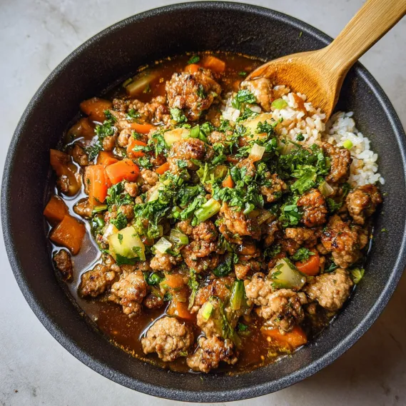 A bowl of food with a wooden spoon.
