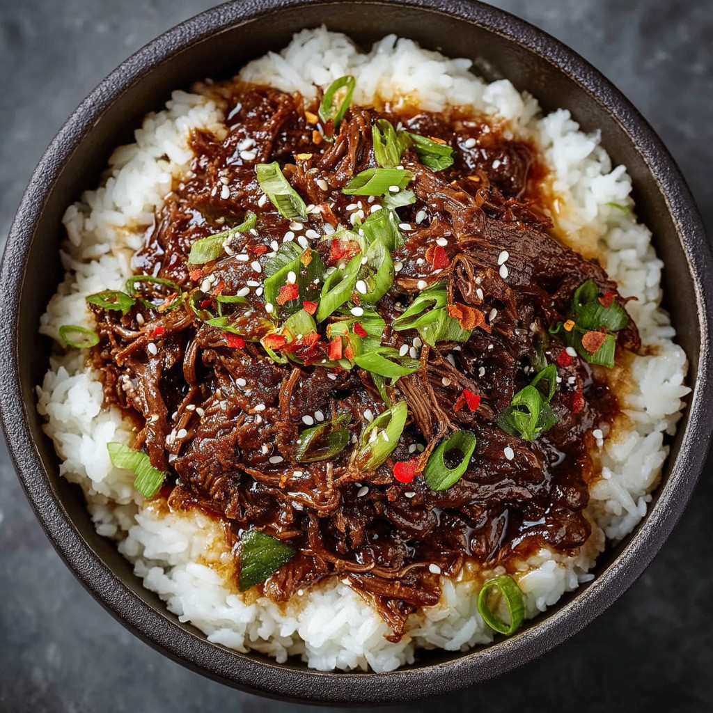 A bowl of rice with meat on top.