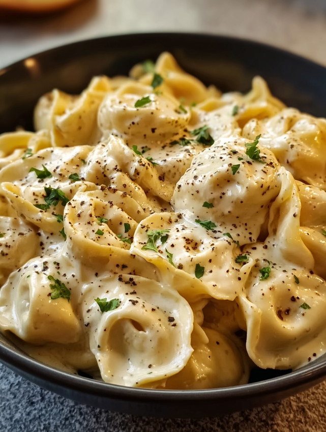 A bowl of pasta with white sauce.
