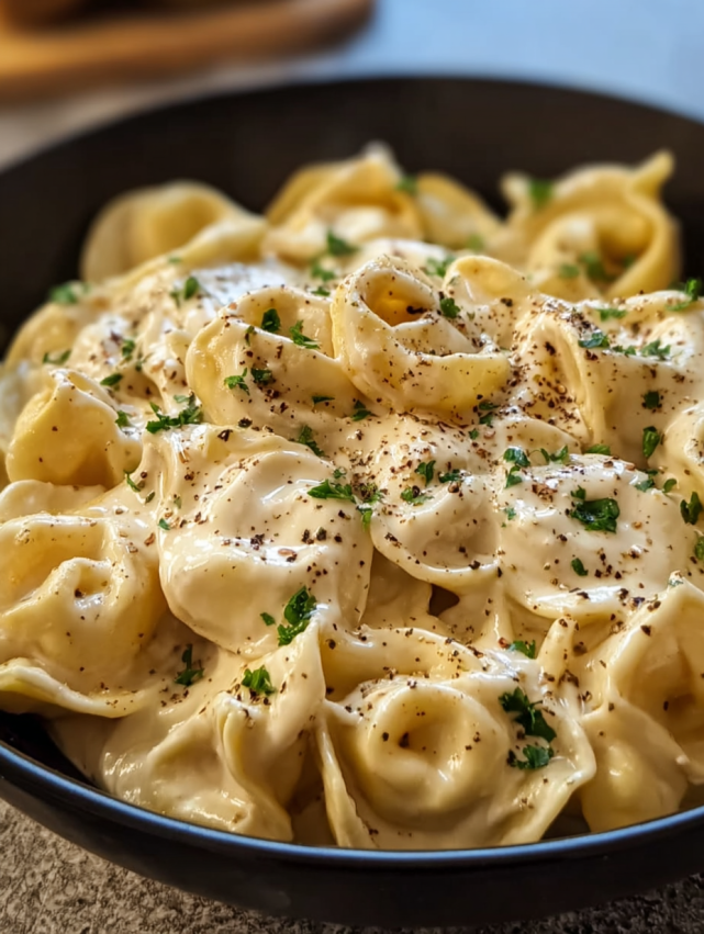 A bowl of pasta with cheese and herbs.