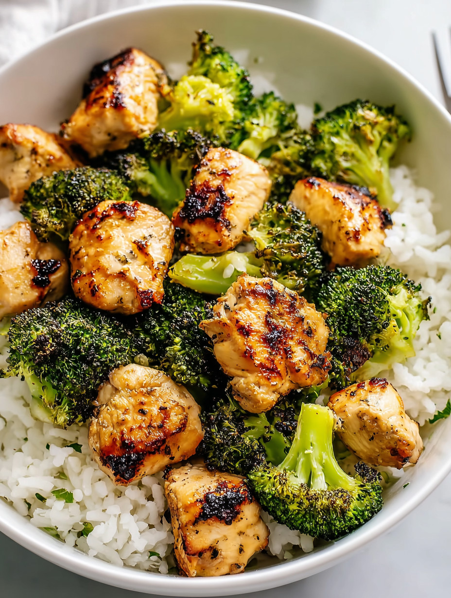 A bowl of rice with chicken and broccoli.