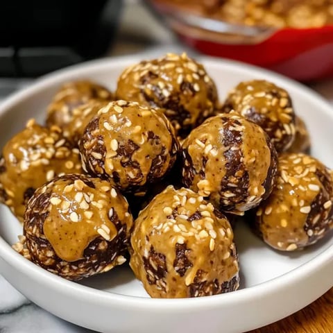 A bowl of brown balls with a spoon in it.